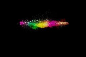 esplosione di polvere multicolore astratta su sfondo nero. congelare il movimento di schizzi di particelle di polvere colorate. dipinto holi. foto