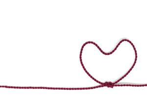 nodo a forma di cuore su una corda su uno sfondo bianco foto