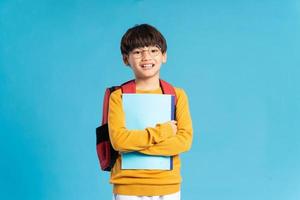 ritratto di asiatico scuola ragazzo Nato su un' blu sfondo foto