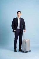 ritratto di asiatico uomo d'affari indossare un' completo da uomo e traino un' valigia foto