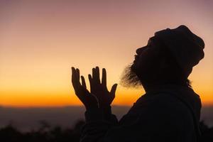 silhouette di uomo in ginocchio giù preghiere per culto Dio a cielo sfondo. cristiani pregare per Gesù Cristo per calma. nel mattina persone avuto per un' silenzioso posto e pregato. copia spazio. foto