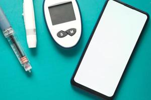 strumenti di misurazione del diabete, insulina e smart phone su sfondo blu