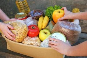 donazione scatola con cibo su vecchio di legno sfondo foto