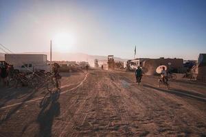 persone a piedi in direzione tramonto a un' Festival nel il deserto a il ardente uomo Festival. foto