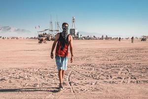 persone a piedi in direzione tramonto a un' Festival nel il deserto a il ardente uomo Festival. foto