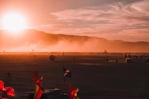 persone a piedi in direzione tramonto a un' Festival nel il deserto a il ardente uomo Festival. foto