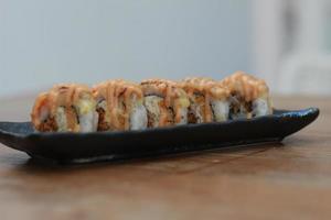 giapponese cibo chiamato salmone mozza Sushi. servito caldo su un' nero rettangolare piatto su il tavolo. foto