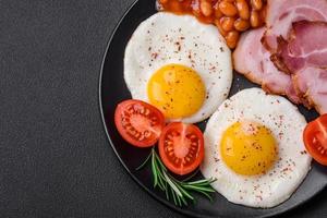 delizioso nutriente inglese prima colazione con fritte uova e pomodori foto