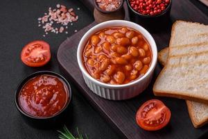 delizioso in scatola fagioli nel un' pomodoro nel un' bianca ceramica ciotola foto