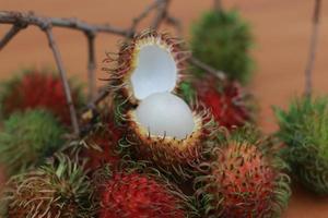 rambutan frutta quale è rossastro verde nel colore avendo dolce gusto isolato su tavolo. cibo concetto foto. foto