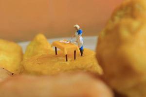 miniatura figura di un' madre cucinando su giallo tofu. foto