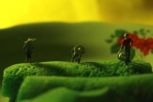 miniatura figure di agricoltori a opera su verde pancake rotoli. concetto di agricoltura foto. foto