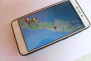 miniatura figura di un esploratore in posa su un' digitale carta geografica attraverso un' mobile Telefono foto