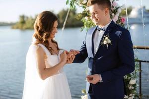 cerimonia di matrimonio su un molo alto vicino al fiume foto