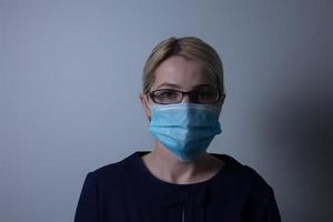 un attraente giovane donna indossa un' carta viso maschera per proteggere se stessa a partire dal il h1n1 virus, isolato su bianca, con camera per il tuo testo foto