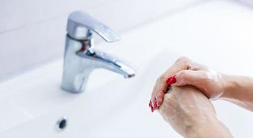 donna lavaggio mani al di sopra di bianca sfondo foto
