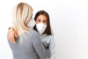 giovane madre indossare protettivo PM2.5 maschera per sua figlia. isolato su bianca sfondo. foto