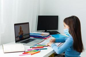 donna video conferenza con precettore su il computer portatile a casa. distanza formazione scolastica concetto. foto