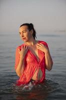 bellissimo anziano donna bagna nel il mare e spruzzi acqua. foto