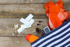 estate Da donna spiaggia Accessori per il tuo mare vacanza e pillola su vecchio di legno sfondo. concetto di medicazione necessario nel viaggio. superiore Visualizza. foto