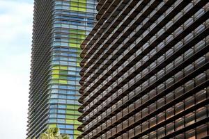 moderno ufficio edificio con colorato bicchiere e palma alberi foto