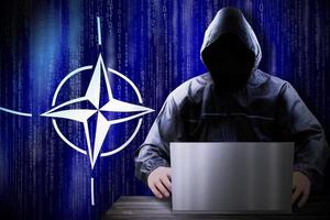 anonimo incappucciato pirata e bandiera di nato, binario codice - informatica attacco concetto foto