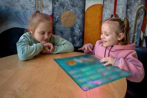 figli, Due ragazze siamo seduta nel un' bar e studiando il menù per ordinazione cibo. foto