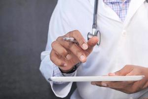 medico in camice bianco sta usando una tavoletta digitale