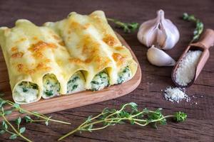 cannelloni con ricotta e spinaci su il di legno tavola foto