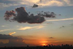 luminosa d'oro nuvoloso cielo nel tramonto sfondo nel città edificio cittadina foto