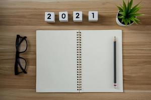 quaderno di carta vuoto con numero anno 2021 per la pianificazione sullo sfondo della tavola di legno