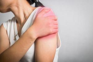 la donna ha dolore alla spalla da un muscolo infortunato foto