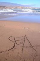 mare scritto nel il sabbia foto