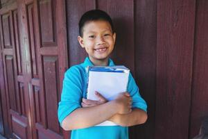 ragazzo che abbraccia i libri foto