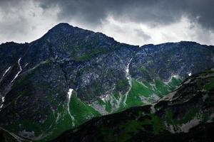 cielo scuro su un picco roccioso in montagna foto