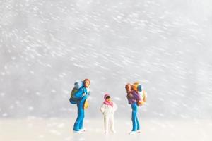 miniatura persone contento famiglia viaggio nel inverno tempo foto