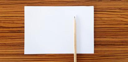 Marrone matita con bianca carta mettendo su di legno tavolo con copia spazio per riempire testo. formazione scolastica, documento e oggetto concetto foto