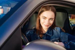 bellissimo giovane signora contento macchina. carino ragazza chi unità auto e sorrisi. ritratto foto