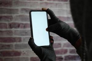 mano di hacker che ruba dati dallo smartphone foto