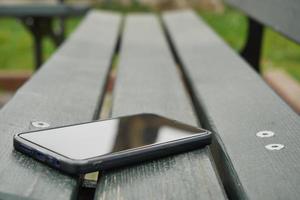 dimenticare smartphone su un' parco panca, perso inteligente Telefono foto