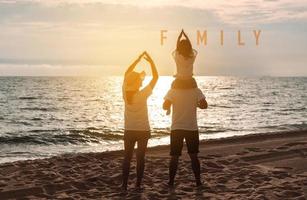 contento asiatico famiglia godere il mare spiaggia a consistente padre, madre e figlia avendo divertimento giocando spiaggia nel estate vacanza su il oceano spiaggia. contento famiglia con vacanze tempo stile di vita concetto. foto