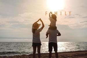 contento asiatico famiglia godere il mare spiaggia a consistente padre, madre e figlia avendo divertimento giocando spiaggia nel estate vacanza su il oceano spiaggia. contento famiglia con vacanze tempo stile di vita concetto. foto