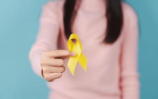 contento donna Tenere giallo nastro, settembre, suicidio prevenzione giorno, infanzia, sarcoma, osso e Vescica urinaria cancro consapevolezza mese, Salute cura supporto persone e mondo cancro giorno concetto foto