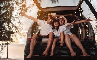 contento famiglia con auto viaggio e campeggio strada viaggio. estate vacanza nel auto nel il tramonto, papà, mamma e figlia contento in viaggio godere insieme guida nel vacanze, persone stile di vita cavalcata di automobile. foto