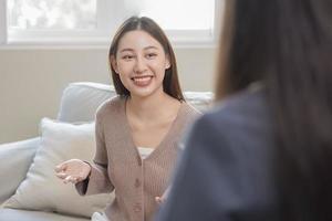 psicologia, depressione. Sorridi asiatico giovane donna paziente mentale spiegato sintomo con psicologo, psichiatra mentre medico donna assunzione Appunti a clinica. incoraggiante, terapia. foto