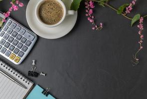 ufficio nero pietra scrivania tavolo con calcolatrice, nero caffè e penna foto