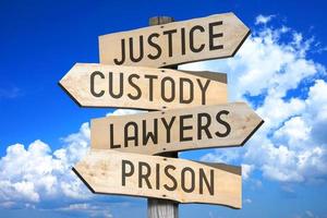 giustizia, custodia, avvocati, prigione - legge, crimine concetto - di legno cartello stradale con quattro frecce foto