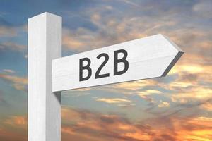b2b, attività commerciale per attività commerciale - bianca di legno cartello stradale con uno freccia e tramonto cielo nel sfondo foto