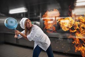 donna capocuoco è preoccupato perché il cucina è su fuoco foto