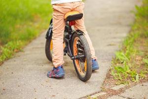 ragazzo con un' bicicletta su il strada. ruota di un' figli di bicicletta foto